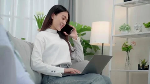 Close up face smiling face asian woman making phone call, working on laptop.. Stock-Footage 244974559