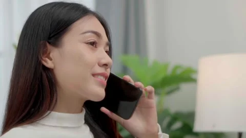 Close up face smiling face asian woman making phone call, working on laptop.. Stock Footage 244974566