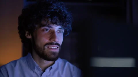 Close-up face of smiling young man watching on monitor screen and working on Stock-Footage 146178658