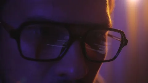 Close-up face of software engineer working on laptop. Line of code in reflection Stock Footage 230887757