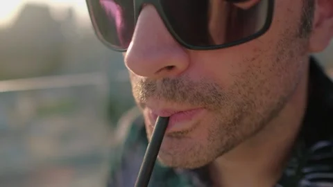 Close up of a face with sunglasses and a straw. Video stock 202248292