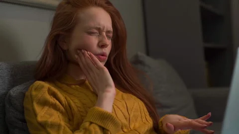 Close-up face of tired sad young woman having pain in tooth while working typing Stock Footage 155018484