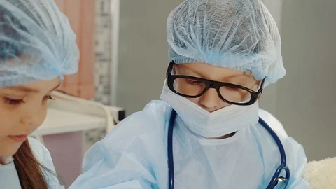 Close-up of face of two cute children, who playing in surgeons Video stock 86573985