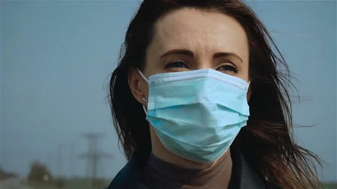 Close up of face of upset caucasian young woman in medical mask looking away to Stock Footage 128741192