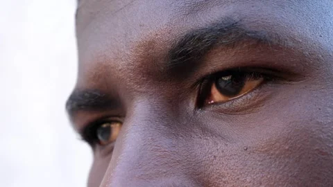 Close up on face of young african man who opens his eyes and stares into space Stock Footage 240393336