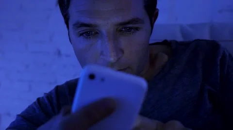 Close up face of young attractive man texting at night on mobile phone Stock Footage 65022040