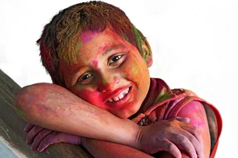 Close up face of young boy playing Holi, smiling colors, white B Stock Photos