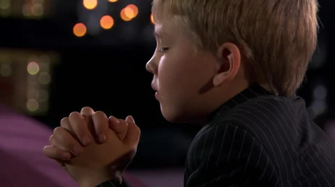 Close-up face of young boy praying with bowed head and folded hands Stock Footage 59548071
