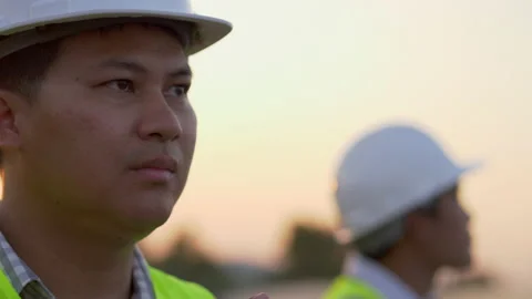 Close up, face of young engineer wearing white helmet while checking  Stock-Footage 198121338