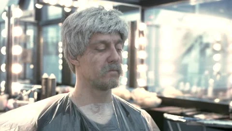 Close-up of the face of a young guy in a wig and a gray mustache and beard. Stock Footage 135992044