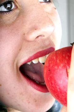 Close up of the face of a young lady with red apple Stock Photos