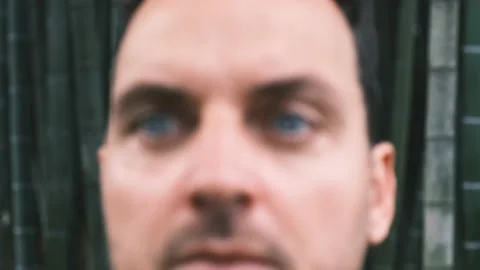 Close-up face of a young man with bright blue eyes against the backdrop of a Stock Footage 199214738