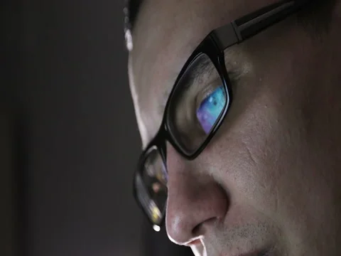 Close-up of the face of a young man with glasses in the dark. Stock Footage 73791466