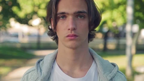 Close up face of an young man is looking to the camera,  in the street. Man w Stock Footage 204156774