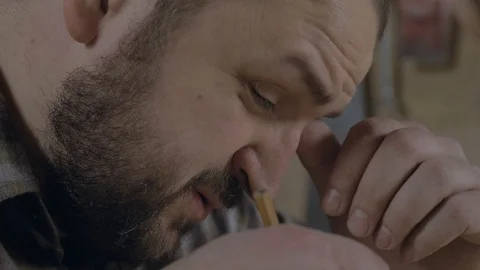 Close-up face of young man thinking and drawing sketch in carpentry workshop Stock Footage 101934318