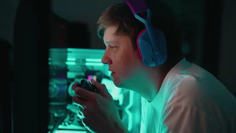 Close-up face of young man wearing headphones and holding using joystick Stock Footage 317162791