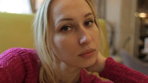 Close up face of a young pretty blonde woman posing to camera in cafe interior Stock Footage 75371121