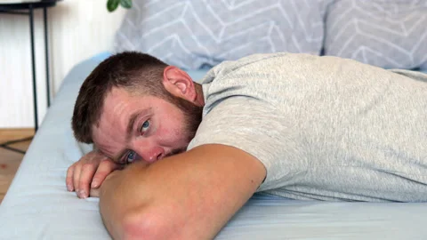 Close-up face of young tired bearded man with blue eyes looking at camera Stock Footage 156703385