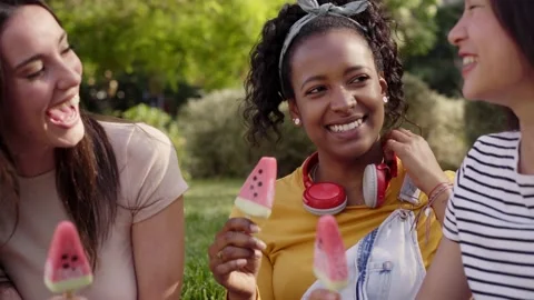 Close up faces three smiling young multi-ethnic women outdoors eating ice cream Stock Footage 234015124