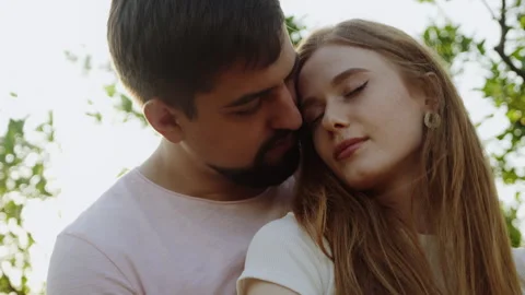 Close-up faces of young couple in love with closed eyes standing hugging Stock Footage 253766322