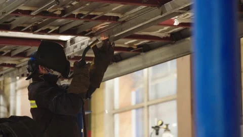 Close-up of factory worker in protective uniform and safety mask welding steel Stock Footage 202049008