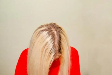 A close-up of a fair-haired woman's head with regrown roots Stock Photos