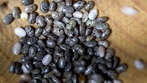 Close-up. Falling chia seeds. Chia seeds oval shape with relief pattern. Stock Footage 220283104