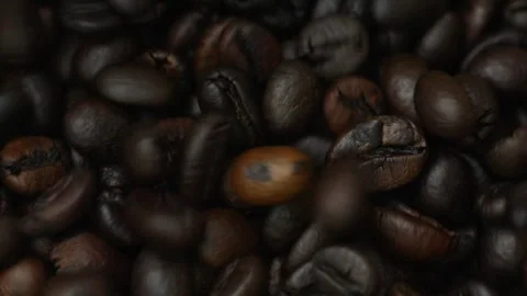 Close-up of falling coffee beans with a pile of coffee beans ready for brewing. Stock Footage 301674354