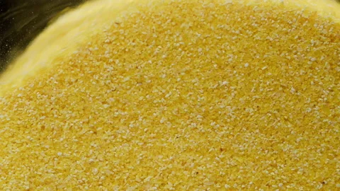 Close-up of falling down wheat into glass jar on black background. Shooting of Stock Footage 155341303