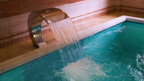 Close-up of falling water in the pool at the Spa hotel resort, waterfall in the  Stock Footage 114326181