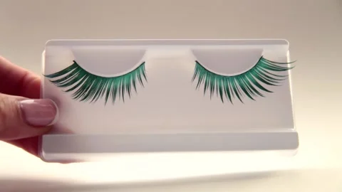 Close-up of false eyelashes. Beautiful green eyelashes on light background Stock Footage 163818151