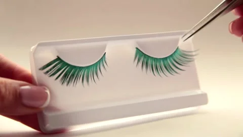 Close-up of false eyelashes. Beautiful green eyelashes on light background Stock Footage 163818155