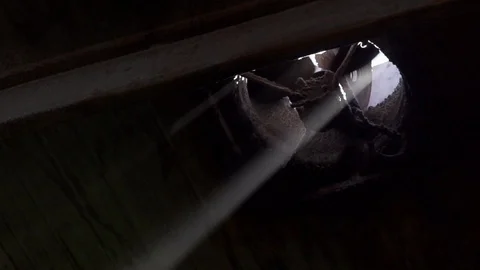 Close up of fan spinning in dark room with light beam coming through Stock Footage 128962352