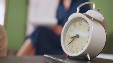 Close up of fancy clock on table with blurred specialist writing in background Stock Footage 310857602