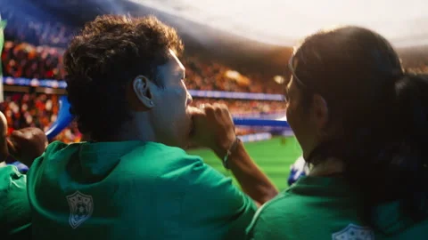 Close up of fans using vuvuzela in stadium tribunes during football match Video stock 337554023