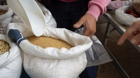 Close up on farmer hands putting rice in the envelope, selling 스톡 동영상 77568603