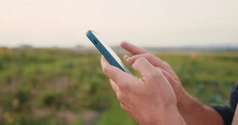 Close up of farmers hands using smartphone and searches for information in Vídeo Stock 250346114