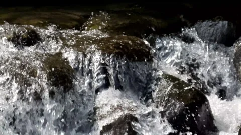 Close up of a fast flowing stream in a rocky mountain waterfall Video stock 320983452