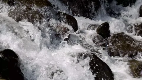 Close up of a fast flowing stream in a rocky mountain waterfall Video stock 320983623