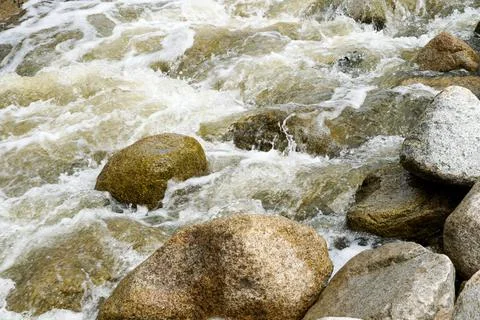 Close up fast flowing water between rocks in the mountain Stock Photos