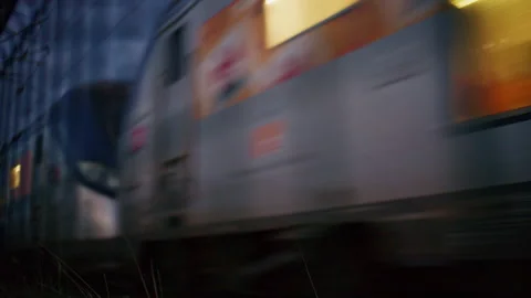 Close up of a fast moving passenger train at night with warm glowing windows and Stock Footage 339751055