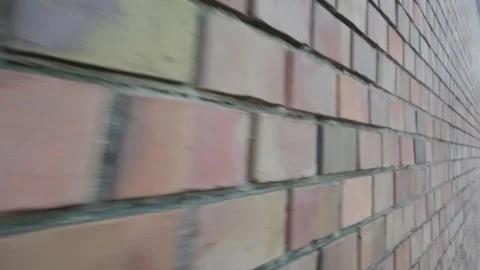 Close-up, fast-moving perspective along a textured brick wall. The dynamic Stock Footage 342108210