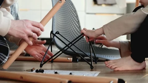 Close up of father and son assembling chair at home Video stock 305945922
