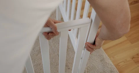 Close up father with assembling baby bed at home. Slow motion Stock Footage 129110456