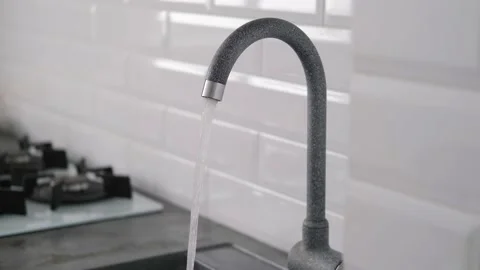 Close-up of a faucet in the kitchen in a stylish interior. Tap water flows. Stock Footage 155516340