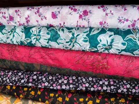 Close-up features a stack of folded fabrics, each boasting unique floral patt Foto stock