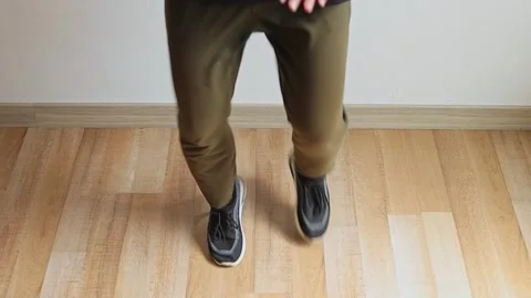 Close-up on feet and legs performing high knee running cardio exercise on wood Stock Footage 345379420