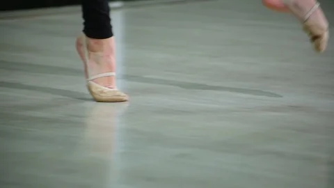 Close-up feet of ballerina in pointe performs dance ballet elements in gym Stock Footage 103434762