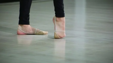 Close-up feet of ballerina in pointe performs dance ballet elements in gym Stock Footage 103434776