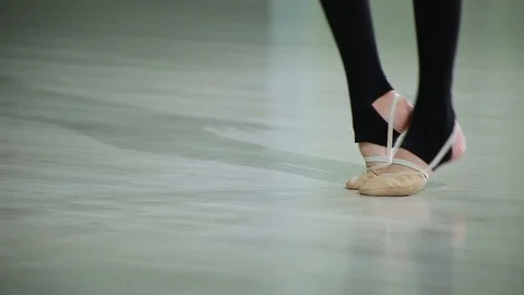 Close-up feet of ballerina in pointe performs dance ballet elements in gym Stock Footage 103434778
